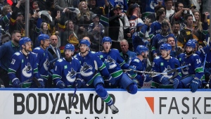 Vancouver Canucks' Brock Boeser, centre, and the rest of the team come off the bench to celebrate after Vancouver defeated the Edmonton Oilers during Game 5 of an NHL hockey Stanley Cup second-round playoff series, in Vancouver, on Thursday, May 16, 2024. THE CANADIAN PRESS/Darryl Dyck