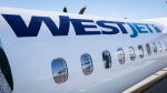 A WestJet plane waits at a gate at Calgary International Airport in Calgary, Alta., Wednesday, Aug. 31, 2022. THE CANADIAN PRESS/Jeff McIntosh