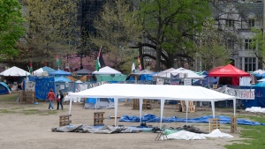 People walk past the pro-Palestinian protest encampment on McGill University campus, in Montreal, Monday, May 13, 2024. (Ryan Remiorz, The Canadian Press)