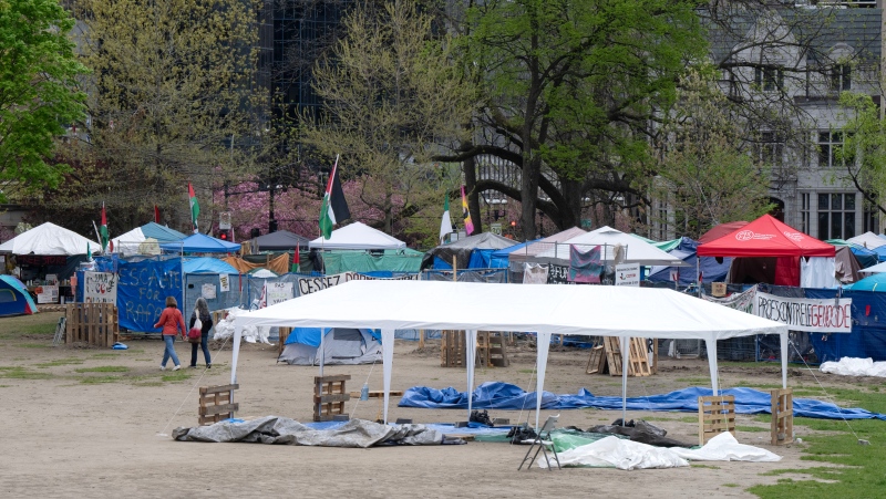 People walk past the pro-Palestinian protest encampment on McGill University campus, in Montreal, Monday, May 13, 2024. (Ryan Remiorz, The Canadian Press)