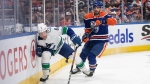 Vancouver Canucks winger Brock Boeser, left, and Edmonton Oilers defenceman Evan Bouchard battle for the puck during NHL playoff action on May 18, 2024, in Edmonton. (Jason Franson/The Canadian Press)