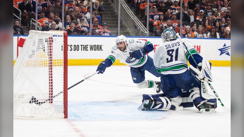 Vancouver Canucks' Carson Soucy (7) tries to stop the puck from going in the net past goalie Arturs Silovs (31) on a goal by the Edmonton Oilers during second period second-round NHL playoff action in Edmonton on Saturday May 18, 2024. THE CANADIAN PRESS/Jason Franson