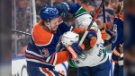 Vancouver Canucks' J.T. Miller (9) and Edmonton Oilers' Mattias Janmark (13) rough it up during first period second-round NHL playoff action in Edmonton on Saturday May 18, 2024.THE CANADIAN PRESS/Jason Franson