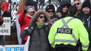 A person yells at a police officer as people protest on the anniversary of the "Freedom Convoy" demonstrations, on Parliament Hill in Ottawa on Saturday, Feb. 17, 2024. THE CANADIAN PRESS/Patrick Doyle