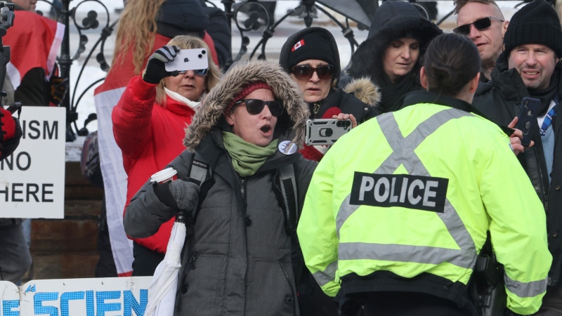 A person yells at a police officer as people protest on the anniversary of the "Freedom Convoy" demonstrations, on Parliament Hill in Ottawa on Saturday, Feb. 17, 2024. THE CANADIAN PRESS/Patrick Doyle