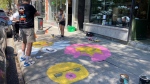 Urban artist Marxilie Martel paints on St-Laurent Boulevard after crews worked to clean up Montreal's Main. (Christine Long, CTV News)