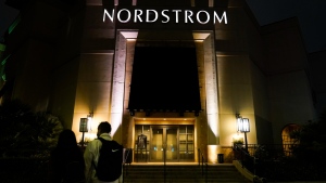 Two pedestrians walk near an entrance to a Nordstrom department store at the Grove mall in Los Angeles, Dec. 2, 2021. (AP Photo/Jae C. Hong, File)