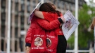 Infected blood campaigners hug during a gathering at Parliament Square, ahead of the publication of the final report into the scandal, in London, May 19, 2024. (Aaron Chown/PA via AP)