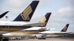 Singapore Airlines planes are seen here on a tarmac in December 2020. Singapore Airlines will reward its employees with a bonus worth nearly eight months of salary. (Kevin Lim/AP via CNN Newsource)