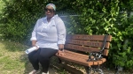 Charla Dopwell sits on a bench dedicated to her 16-year-old son, Jannai Dopwell-Bailey, who was stabbed to death on Oct. 18, 2021. She said Monday she finds 'some comfort' that another person charged in her son's killing was found guilty of second-degree murder. (Olivia O'Malley/CTV News)