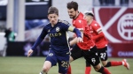 Vancouver Whitecaps FC midfielder Ryan Gauld, left, controls the ball as Cavalry FC midfielder Charlie Trafford chases him during second half soccer action in the Canadian Championship quarterfinal, leg 1, in Calgary, Tuesday, May 7, 2024. THE CANADIAN PRESS/Jeff McIntosh