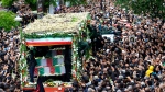 In this photo provided by Fars News Agency, mourners gather around a truck carrying coffins of Iranian President Ebrahim Raisi and his companions who were killed in their helicopter crash on Sunday, during a funeral ceremony at the city of Tabriz, Iran, Tuesday, May 21, 2024. (Ata Dadashi, Fars News Agency via AP)