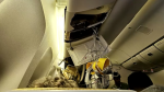 An air mask hangs from the airplane's damaged ceiling. (Reuters)