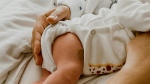 A mother holds a newborn. (Büşranur Aydın/pexels.com)