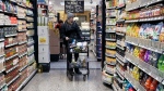 A woman checks prices as she shops at a grocery store on Friday, Jan. 19, 2024. (AP Photo/Nam Y. Huh)