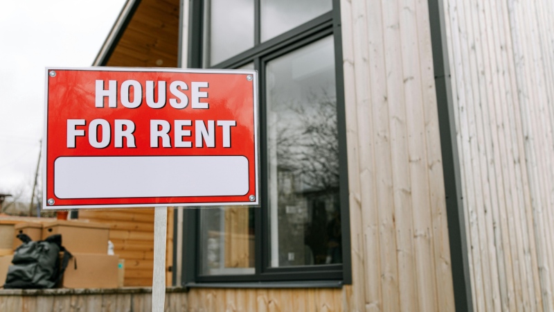 A for rent sign is shown in front of a house. (Pexels/Ivan Samkov)