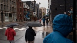 Pedestrians shield themselves from heavy rain falling in Halifax in this file photo. (Source: THE CANADIAN PRESS/Darren Calabrese)