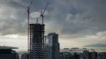 Cranes are seen above a condo tower under construction in downtown Vancouver, on Thursday, January 19, 2023. THE CANADIAN PRESS/Darryl Dyck