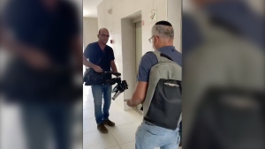 In this image from video, Israeli officials seize AP video equipment from an apartment block in Sderot, Southern Israel, Tuesday, May 21, 2024. (Josphat Kasire / AP Photo)