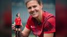 Christine Sinclair poses with a Barbie doll made in her likeness. (CNW Group/Mattel Canada, Inc.)