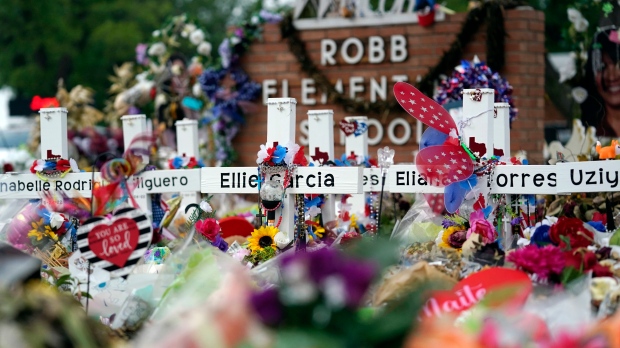 Crosses are surrounded by flowers and other items at a memorial, Thursday, June 9, 2022, for the victims of a shooting at Robb Elementary School in Uvalde, Texas. (AP Photo/Eric Gay)
