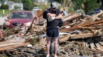 Local residents hug in front of their tornado damaged home, Wednesday, May 22, 2024, in Greenfield, Iowa. (AP Photo/Charlie Neibergall)