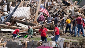 Local residents clean up debris from a home damaged by a tornado  Wednesday, May 22, 2024, in Greenfield, Iowa. (Charlie Neibergall / AP Photo)