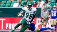 Winnipeg Blue Bombers defensive back Juan Lua (32) attempts to tackle Saskatchewan Roughriders receiver Ajou Ajou (75) as he runs the football during second the half of preseason CFL football action in Regina, on Monday, May 20, 2024. THE CANADIAN PRESS/Heywood Yu