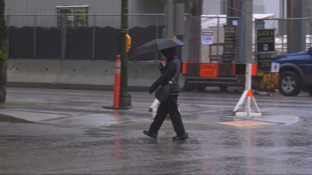 A pedestrian walks with an umbrella in the rain in downtown Winnipeg on May 24, 2024. (Joseph Bernacki/CTV News Winnipeg)
