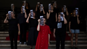Relatives and supporters of Israeli hostages held by Hamas hold photos of their loved ones during a performance calling for their return in Tel Aviv on Thursday, May 23, 2024. (Oded Balilty / AP Photo)
