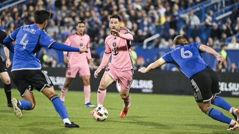 Inter Miami's Lionel Messi pushes forward as CF Montreal's Fernando Alvarez and Samuel Piette defend during first half MLS soccer action against CF Montreal in Montreal, Saturday, May 11, 2024. THE CANADIAN PRESS/Graham Hughes