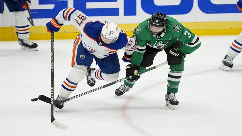 Edmonton Oilers center Connor McDavid (97) competes for the puck agains Dallas Stars defenseman Chris Tanev (3) during the third period in Game 1 of the NHL hockey Western Conference Stanley Cup playoff finals, Thursday, May 23, 2024, in Dallas. (AP Photo/Tony Gutierrez)