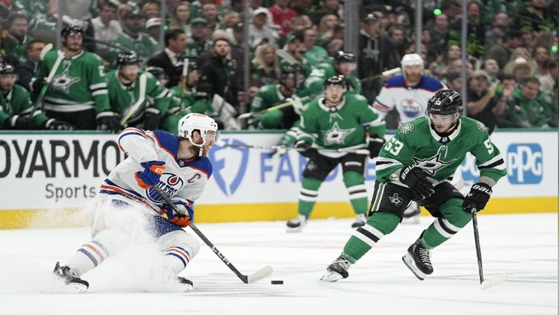Edmonton Oilers centre Connor McDavid (97) works to get the puck past Dallas Stars centre Wyatt Johnston (53) during the first period of Game 1 of the Western Conference finals in the NHL hockey Stanley Cup playoffs Thursday, May 23, 2024, in Dallas. (AP Photo/Tony Gutierrez)