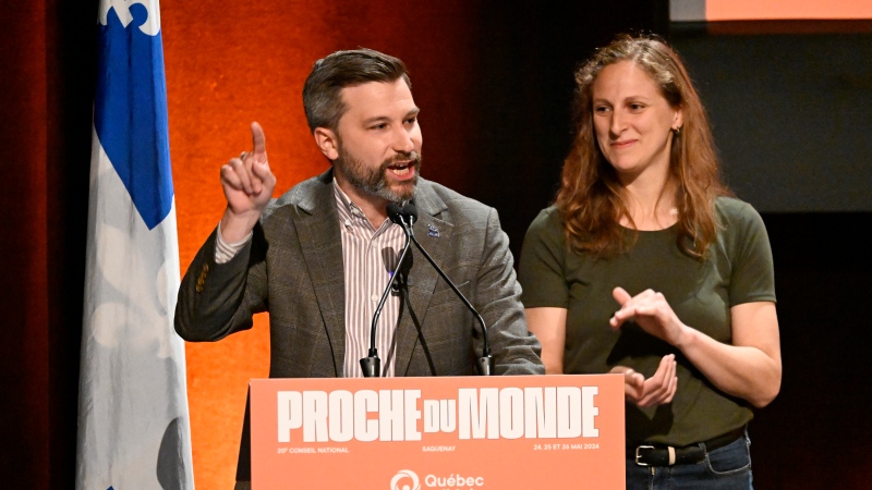 Quebec Solidaire co-spokesperson Gabriel Nadeau-Dubois, left, speaks to delegates at the beginning Quebec Solidaire national council meeting, Saturday, May 25, 2024 in Saguenay as co-spokesperson Christine Labrie, right, applauds. THE CANADIAN PRESS/Jacques Boissinot
