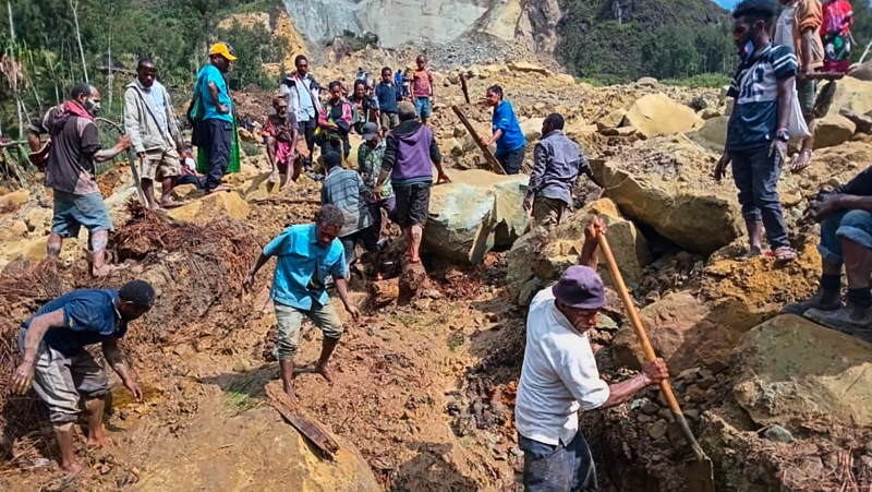 Villagers search through a landslide in Yambali, in the Highlands of Papua New Guinea, Sunday, May 26, 2024. (Mohamud Omer/International Organization for Migration via AP)