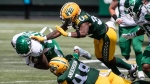Saskatchewan Roughriders' Geronimo Allison (80) is tackled by Edmonton Elks' Nick Anderson (48) and Leon O'Neal Jr. (32) during first half CFL pre-season action in Edmonton, Alta., on Saturday May 25, 2024. (THE CANADIAN PRESS/Jason Franson)