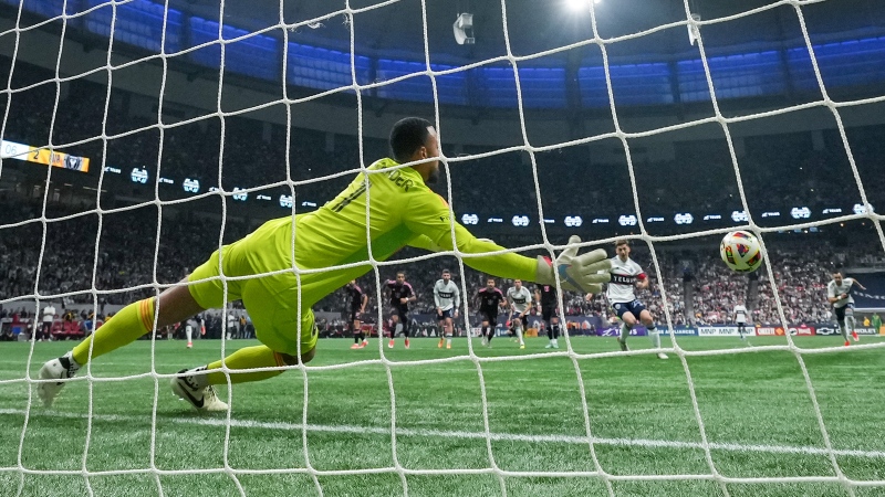 Vancouver Whitecaps' Ryan Gauld, back right, scores against Inter Miami goalkeeper Drake Callender on a penalty kick during the second half of an MLS soccer match, in Vancouver, on Saturday, May 25, 2024. THE CANADIAN PRESS/Darryl Dyck