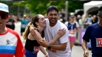 Runners embrace as they cross the finish after completing the half marathon of the Ottawa Race Weekend in Ottawa, on Sunday, May 26, 2024. THE CANADIAN PRESS/Justin Tang