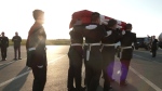 A casket of an unknown soldier arrives in St. John’s and is carried into a hearse by pallbearers. (CTV)