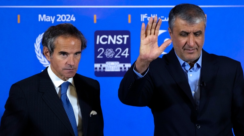 Head of Iran's atomic energy department Mohammad Eslami waves to media at the conclusion of his joint press conference with International Atomic Energy Organization, IAEA, Director General Rafael Mariano Grossi, left, after their meeting in the central city of Isfahan, Iran, Tuesday, May 7, 2024. (AP Photo/Vahid Salemi)