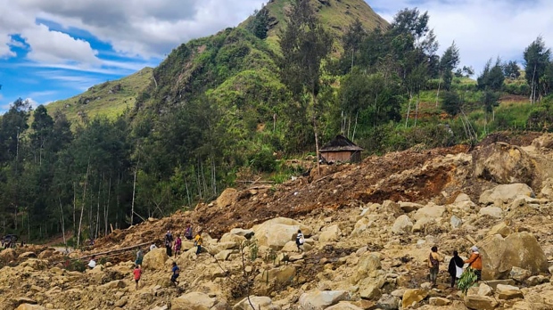 Villagers search amongst the debris after a devastating landslide in Papua New Guinea, Monday, May 27, 2024. (Mohamud Omer/International Organization for Migration via AP)