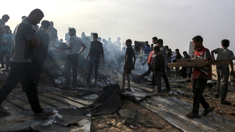 Palestinians look at the destruction after an Israeli strike where displaced people were staying in Rafah, Gaza Strip, Monday, May 27, 2024. (AP Photo/Jehad Alshrafi)