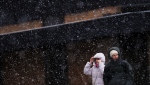 People make their way through a heavy snowfall in Ottawa on Thursday, April 4, 2024. (THE CANADIAN PRESS/Sean Kilpatrick)