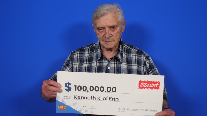 Kenneth Keki of Erin poses with a large novelty cheque after winning $100,000 with OLG's Instant Lucky game. (Submitted: OLG) 