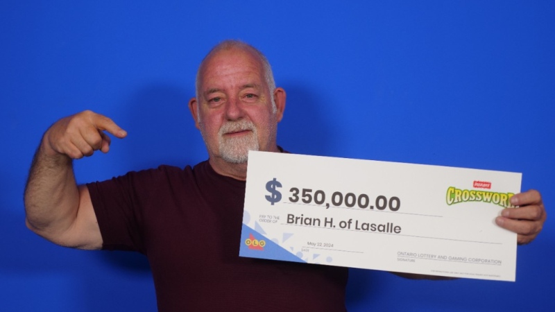 Brian Hopson collects his winnings after playing Instant Crossword Extreme. (Source: OLG)