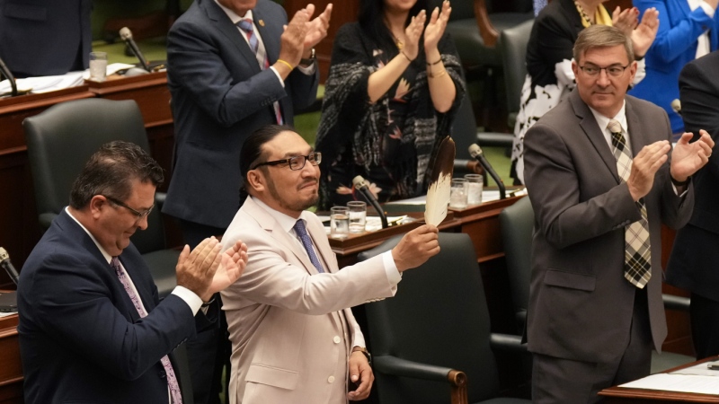 NDP MPP Sol Mamakwa holds an eagle feather as he stands in the Ontario legislature in Toronto, on Tuesday, May 28, 2024, and speaks in his language, Oji-Cree, the first time in history that Indigenous language has been used in the provincial legislature to ask a question of the government. (Chris Young/THE CANADIAN PRESS)