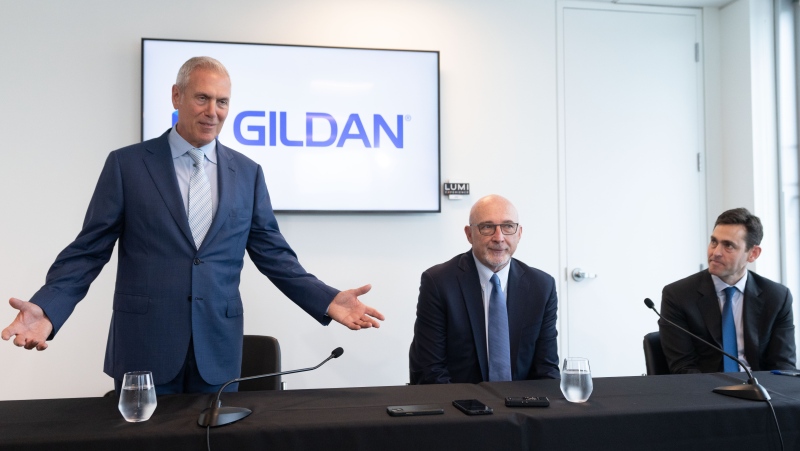Gildan Activewear Inc. CEO Glenn Chamandy, from left to right, with chairman Michael Kneeland and Browning West partner Peter Lee arrive to speak to the media following their annual meeting in Montreal, Tuesday, May 28, 2024. (Christinne Muschi, The Canadian Press)