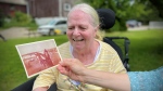 Ronna Weatherly holds up an old picture of her mother, Carole Coulson, with a horse. (Spencer Turcotte/CTV News)