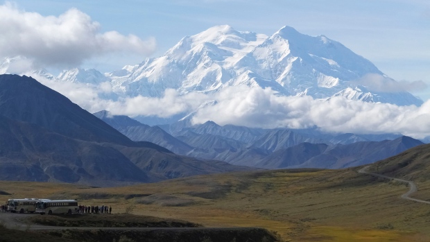FILE - Sightseeing buses and tourists are seen at a pullout popular for taking in views of North America's tallest peak, Denali, in Denali National Park and Preserve, Alaska, on Aug. 26, 2016. (AP Photo/Becky Bohrer, File)