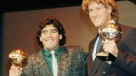 Argentina's soccer star Diego Maradona, left, and West German goalkeeper Harald Schumacher are holding their World Cup Soccer Ball awards while posing with two young soccer players during the Soccer Golden Shoe Award ceremony held in Paris, France, on Nov. 13, 1986.  (AP Photo/Michael Lipchitz, File)